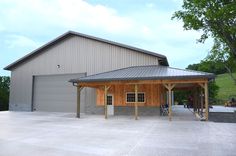 a large building with a metal roof and two garages on the side of it