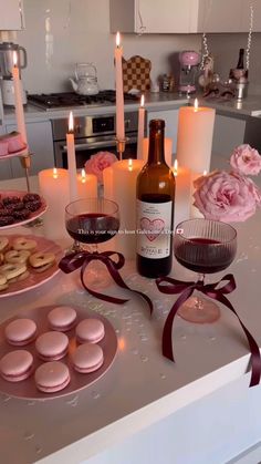 pink macaroons, wine and candles on a kitchen counter