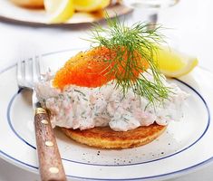 a plate topped with crab salad next to a knife and fork