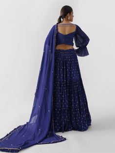 A three-piece Purple lehenga set from the Suruchi Parakh collection. This elegant georgette crepe lehenga is paired with a hand-embroidered blouse. The outfit is completed with a matching georgette crepe dupatta. The bell sleeve blouse has a cutwork neckline. And, the purple dupatta has a beautiful touch of ruffle with an embellished border. Festive Georgette Sets For Reception, Reception Georgette Palazzo Set With Zari Work, Georgette Palazzo Set With Zari Work For Reception, Festive Georgette Saree Sets, Georgette Sets With Zari Work For Navratri, Eid Festival Georgette Sets With Unstitched Blouse, Semi-stitched Georgette Sets For Festive Occasions, Eid Sets With Unstitched Georgette Blouse, Elegant Georgette Choli With Dori Work