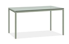 a table with a glass top and metal legs, against a white background or backdrop