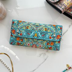 "This Boho wallet is made of Turkish carpet patterned brocade fabric and vegan leather. Its ethnicity and elegance comes from the traditional Turkish carpet motives used on the front and the back. These kilim wallets are designed and made in Cappadocia,Turkey. Cappadocia is known for its distinctive \"fairy chimneys,\" tall, cone-shaped rock formations. Besides these natural beauties, Cappodocia is famous with Its wine, horses, hot air balloons and handwoven carpets. The designs of our wallets a Handmade Blue Rectangular Wallet, Multicolor Clutch Wallet With Card Slots, Multicolor Clutch With Card Slots As Gift, Blue Clutch With Card Slots As Gift, Blue Clutch With Card Slots For Gift, Artisan Rectangular Wallets For Daily Use, Multicolor Rectangular Trifold Wallet For Daily Use, Bohemian Wallet With Card Slots For Daily Use, Traditional Wallets With Card Slots For Everyday Use