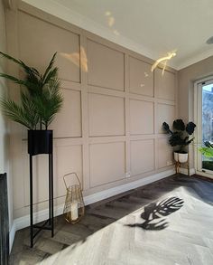 a living room with a large window and two planters on the floor in front of it