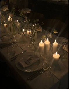 a table set with candles and place settings