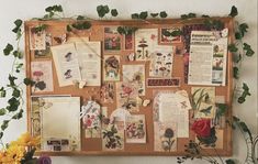 a bulletin board covered in lots of papers and flowers