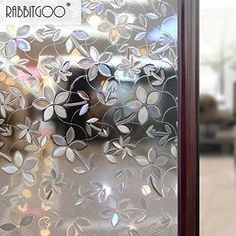 a close up of a frosted glass door with flowers and leaves on the outside