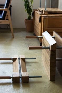 several pieces of wood sitting on top of a floor next to a chair and potted plant