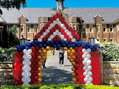 an arch made out of balloons in front of a building