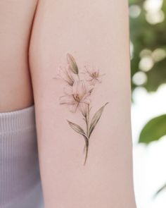 a woman's arm with a flower tattoo on the back of her left arm