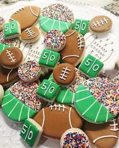 cookies decorated with footballs and sprinkles on a plate