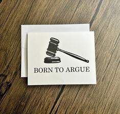 a piece of paper with the words born to arge on it sitting next to a judge's hammer