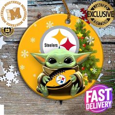 a christmas ornament with a baby yoda holding a football