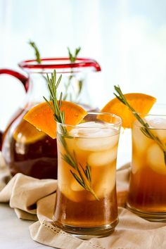 two glasses filled with liquid and garnished with orange slices