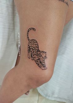 a cat tattoo on the leg of a woman