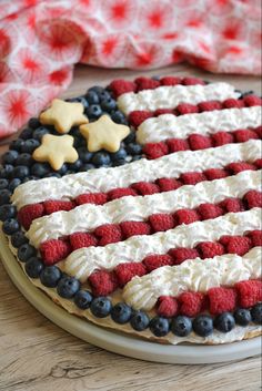 an american flag cake decorated with berries and blueberries