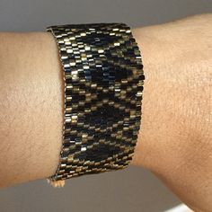 Shiny Black And Gold Bracelet With Adjustable Closure. Black Beaded Cuff Bangle Bracelet, Black Adjustable Jubilee Cuff Bracelet, Adjustable Black Jubilee Cuff Bracelet, Black And Gold Bracelet, Black And Gold, Womens Jewelry Bracelets, Frosting, Cuff Bracelets, Gold Bracelet