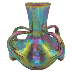 a multicolored glass vase sitting on top of a table