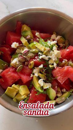 watermelon salad with feta cheese and pistachios in a silver bowl