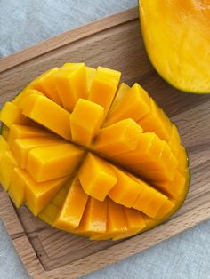 a cut up mango sitting on top of a wooden cutting board