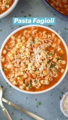 a white bowl filled with pasta and cheese on top of a blue tablecloth next to silverware