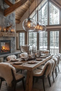 a dining room table with chairs and a fire place in the corner, surrounded by windows