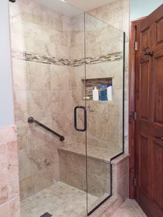 a walk in shower sitting next to a wooden door