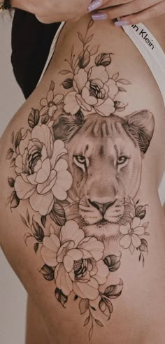 a close up of a woman's stomach with flowers and a tiger on it