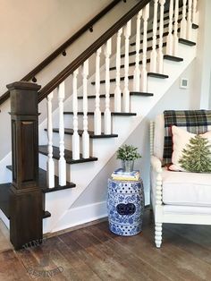 a white chair sitting next to a stair case on top of a hard wood floor