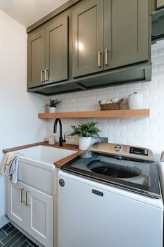 a washer and dryer sitting in a kitchen next to cabinets on the wall