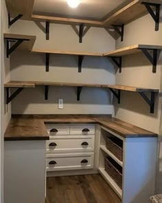 an empty pantry with open shelving and drawers on the wall, in a home