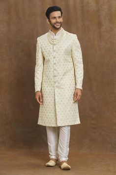 Cream sherwani with all over floral patterns and placed crystal embroidery.
Components: 1
Pattern: Embroidered
Type Of Work: Floral, Crystal
Neckline: Mandarin Collar
Sleeve Type: Full
Fabric: Silk Brocade
Color: Cream
Other Details: 
Straight silhouette
Closure: Front button
Note: Churidar and neckpiece worn by the model is not for sale
Occasion: Sangeet,Mehendi and Puja - Aza Fashions Gold Sherwani With Mirror Work For Diwali, Semi-stitched Sherwani With Mirror Work For Wedding, Wedding Nehru Jacket With Mirror Work, Traditional Drape Sherwani With Mirror Work For Wedding, Reception Sherwani With Dabka Work And Kundan, Traditional Wear With Naqshi For Diwali Reception, Wedding Sherwani With Mirror Work For Diwali, Eid Sherwani With Kundan And Zari Work, Bollywood Style Kundan Sherwani For Eid