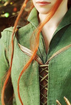 a woman with long red hair wearing a green dress