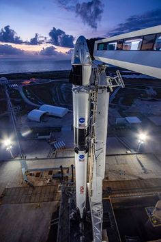 the space shuttle is parked on top of the building at night, ready to take off