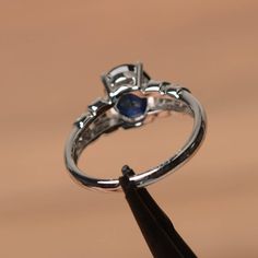 It is a lab sapphire ring. The main stone is 7 mm*9 mm oval cut.weight about 2.32 carats. The basic metal is sterling silver and plated with rhodium. To change the metal to a solid gold (white/rose) or platinum is also available, please ask for a quotation if you want. You can also go to my shop Home for more elegant rings: https://www.etsy.com/shop/godjewelry?ref=hdr_shop_menu Sapphire is the September birthstone. More sapphire rings: https://www.etsy.com/shop/godjewelry?section_id=20715031 Cus Oval Sapphire Promise Ring In 14k White Gold, Silver Oval Sapphire Birthstone Ring, Silver Oval Sapphire Ring, Oval Sapphire Jewelry In 14k White Gold, 14k White Gold Sapphire Jewelry In Oval Shape, Oval Lab-created Sapphire Birthstone Jewelry, Oval Birthstone Jewelry With Lab-created Sapphire, Silver Sapphire Ring With Oval Cabochon, Silver Sapphire Oval Cabochon Ring