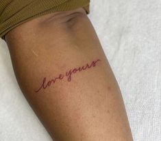 a woman's arm with the word love you written on it, in cursive font