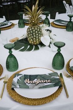 a pineapple centerpiece sits on top of a table set for a tropical themed party