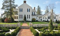 a large white house sitting on top of a lush green field