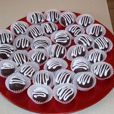 a red plate filled with chocolates sitting on top of a white and red table