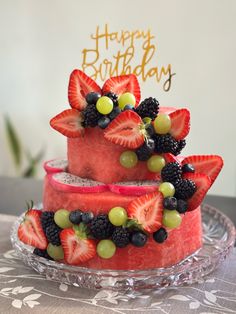 two tiered watermelon cake decorated with berries and blackberries on a glass plate