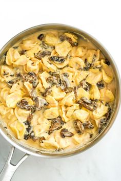 a pot filled with pasta and mushrooms on top of a stove