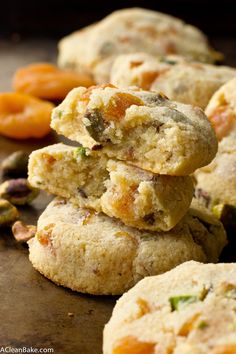 several cookies stacked on top of each other next to oranges and pistachio