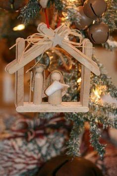 a nativity ornament hanging from a christmas tree