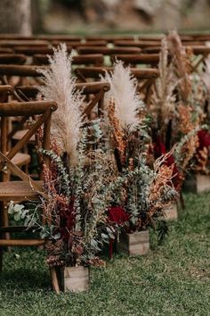 an outdoor ceremony setup with flowers and pamodia in vases on the grass