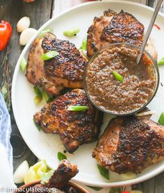 grilled pork chops on a white plate with sauce