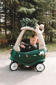 a young boy riding in a toy car