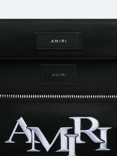 Accented with the season's embroidered AMIRI staggered logo, this utilitarian bag updates a classic silhouette through refinements in form and material. Adjustable straps with custom AMIRI hardware make this bag suitable for multiple stylings, from crossbody to belt bag wear. Pre-Spring 2024 Collection 100% NYLON DRY CLEAN ONLY Luxury Bags With Logo For On-the-go, Luxury Logo Bags For On-the-go, Rectangular Shoulder Bag With Designer Logo For Travel, Designer Logo Rectangular Shoulder Bag For Travel, Rectangular Designer Shoulder Bag For Travel, Rectangular Travel Shoulder Bag With Designer Logo, Designer Shoulder Bag With Embroidered Logo For Everyday, Luxury Bags With Logo Hardware For On-the-go, Luxury Travel Belt Bag With Logo