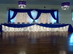 an empty dance floor with blue drapes and lights