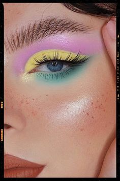 a woman's eye with yellow and blue makeup