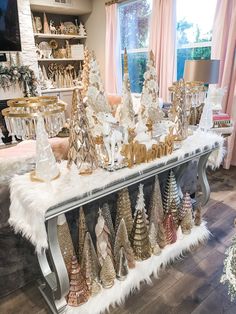 a table topped with lots of gold and white christmas trees