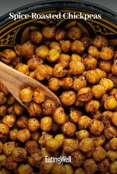 roasted chickpeas in a black bowl with a wooden spoon on the side and text spice - roasted chick peas